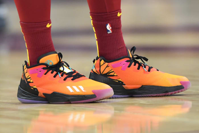 A detailed view of orange and black Adidas shoes.